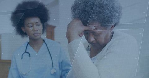 Concerned nurse attending to senior woman experiencing discomfort