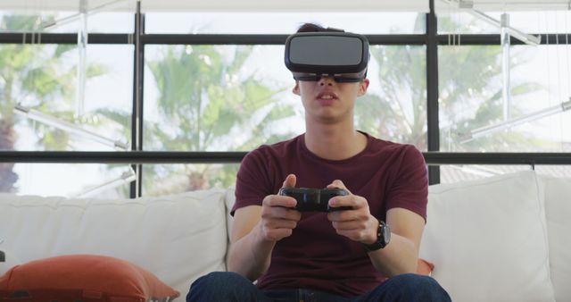 Young Man Wearing VR Headset and Gaming on Couch - Download Free Stock Images Pikwizard.com
