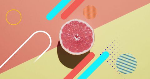 Halved grapefruit on colorful abstract geometric background