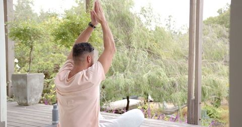 Man Meditating Outdoors on Wooden Deck Amidst Nature