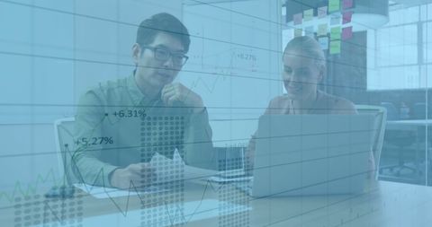 Business Colleagues Analyzing Financial Data Using Laptops