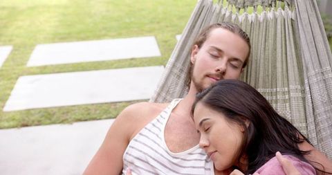 Young Interracial Couple Relaxing in Backyard Hammock