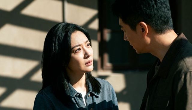 Tense couple confronting in sunlit hallway with dramatic slatted shadows and denim jackets