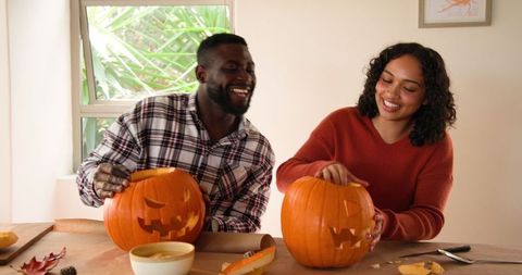 Couple Enjoying Pumpkin Carving Activity for Halloween Season