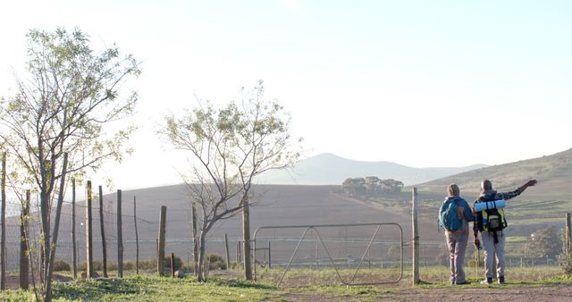 Two Hikers with Backpacks Approaching Scenic Rural Landscape - Download Free Stock Images Pikwizard.com