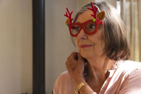 Senior woman in quirky christmas glasses enjoys festive moments