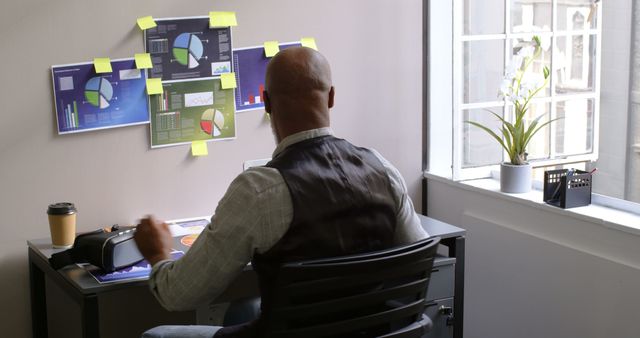 Businessman Analyzing Data on Office Wall Charts While Working at Desk - Download Free Stock Images Pikwizard.com