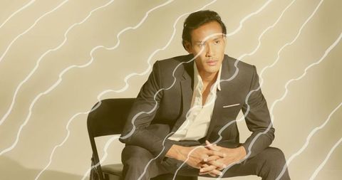 Confident asian man in suit with modern abstract overlay design