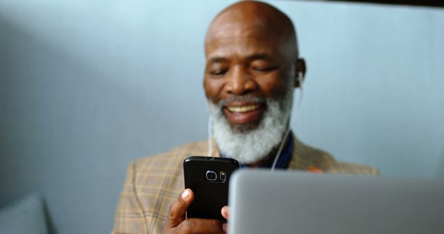 Senior man using smartphone while working on laptop - Download Free Stock Images Pikwizard.com