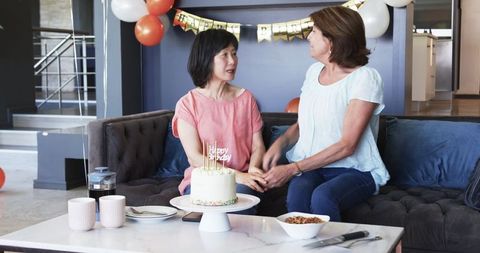 Senior Friends Celebrating Birthday with Cake and Balloons
