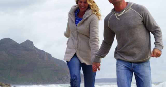 Joyful Middle-Aged Couple Walking by the Seashore - Download Free Stock Images Pikwizard.com