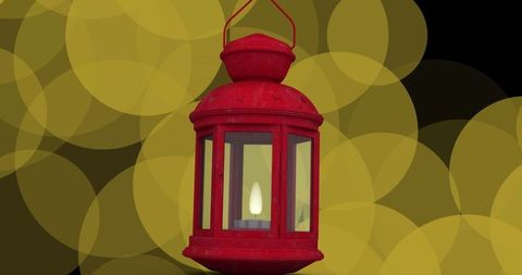 Vintage red lantern with candlelight and golden bokeh background