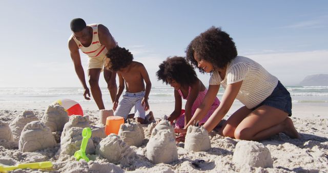 Happy family enjoying time together building sandcastles on a sunny beach. Perfect for depicting summer fun, family vacations, childhood memories, and outdoor activities. Ideal for advertisements, travel promotions, family-oriented content, and lifestyle blogs.