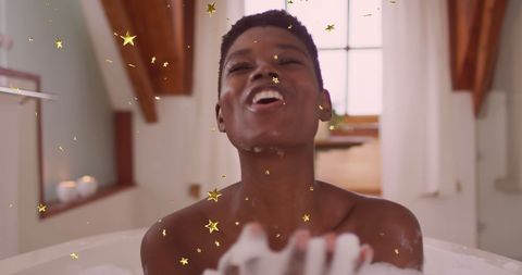 Joyful African American Woman Relaxing in Bathtub with Floating Stars