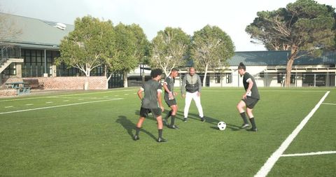 Soccer coach guiding young team during outdoor practice