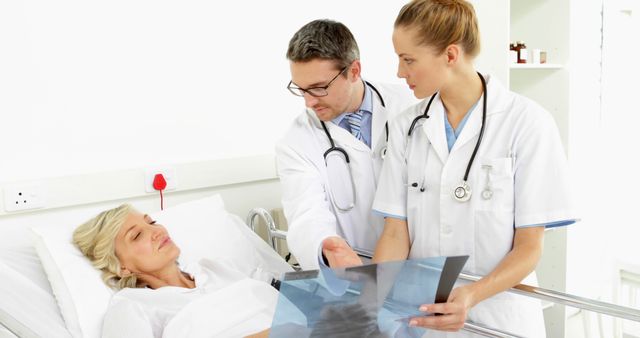 Doctors Discussing X-Ray Results with Female Patient in Hospital Bed - Download Free Stock Images Pikwizard.com