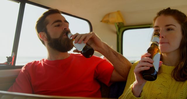 Young couple drinking beer in van. Having fun during roadtrip 4k