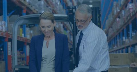 Supervisor and Logistics Manager Reviewing Stock in Warehouse