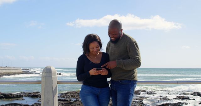 Happy Couple Enjoying Smartphone on Beachfront - Download Free Stock Images Pikwizard.com