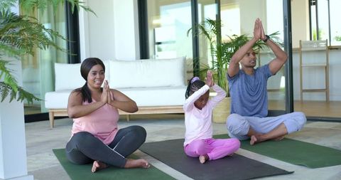 Diverse family practicing outdoor yoga on patio mats promoting wellness and mindfulness