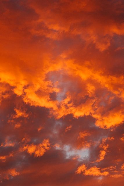 Featuring vivid orange clouds illuminated during sunset, suggesting drama and beauty of nature. Ideal for use in backgrounds, websites, inspirational content, weather journalism, poster designs and travel advertisements.