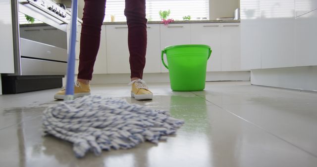 Caucasian woman cleaning floor with mop and bucket of water at home. Lifestyle and domestic life concept.