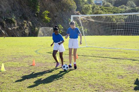 Teen Girls Practicing Soccer Drills on Field Bright Day