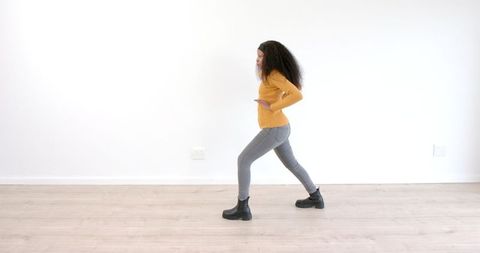Woman in Yellow Sweater Stretching with Forward Lunge for Fitness Exercise