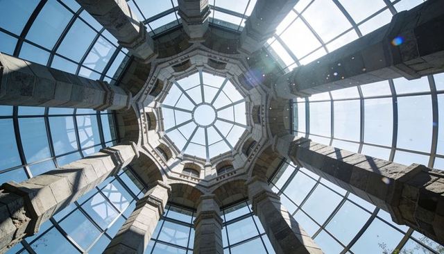 Sunlit glass dome skylight atrium with octagonal oculus and historic stone columns