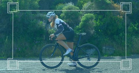 Woman Biking on Road in Natural Landscape