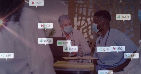 Medical team collaborating on patient records in clinic, doctors wearing masks and scrubs