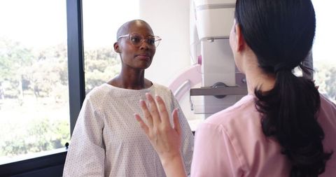 African american woman receiving mammogram consultation with female technologist in clinic