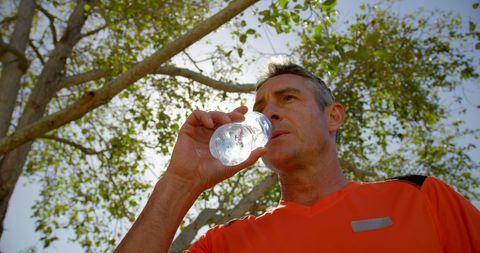 Active Elderly Man Hydrating During Outdoor Exercise