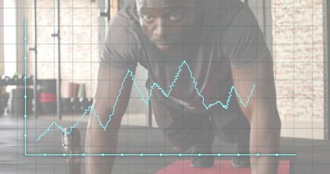 Focused male athlete holding plank in industrial gym with live performance chart overlay