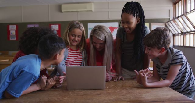 Diverse Group of Schoolchildren Collaborating on Laptop in Classroom - Download Free Stock Images Pikwizard.com