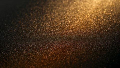 Golden glitter texture sparkling with warm bokeh macro light luxurious metallic surface