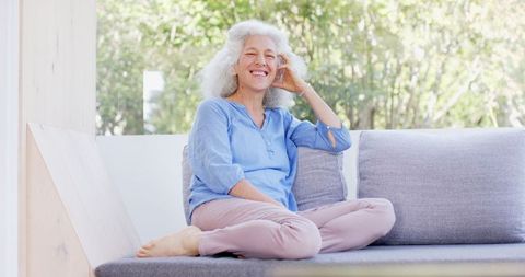Senior Woman Relaxing on Sofa Smiling Joyful Lifestyle