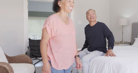 Elderly Couple Sharing Joyful Conversation in Cozy Bedroom