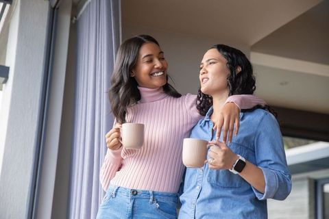 Affectionate Women Enjoying Coffee at Home by Large Window