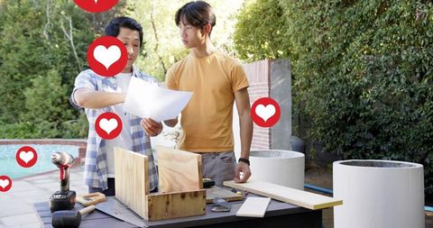 Young asian men building diy wood box on backyard patio with social heart icons and plans