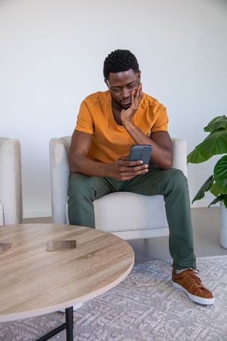Individual Relaxing with Smartphone in Modern Living Room