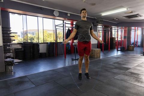 Athlete jumping rope in gym during intense cardio workout on rubber flooring
