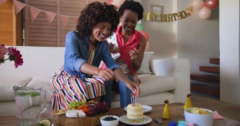 Diverse Female Couple Celebrating Birthday at Home with Cake