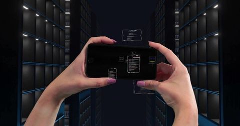 Hands holding smartphone tapping holographic ui in futuristic datacenter aisle monitoring racks