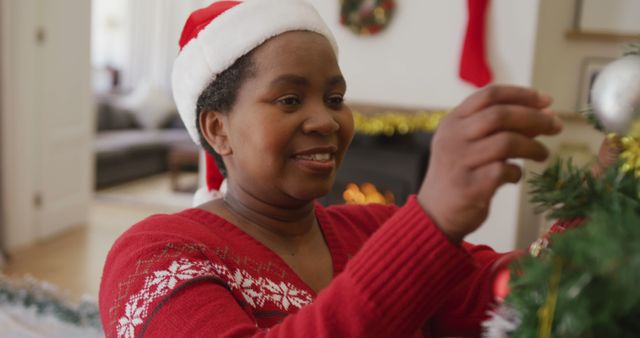 Woman Decorating Christmas Tree at Home with Santa Hat - Download Free Stock Images Pikwizard.com