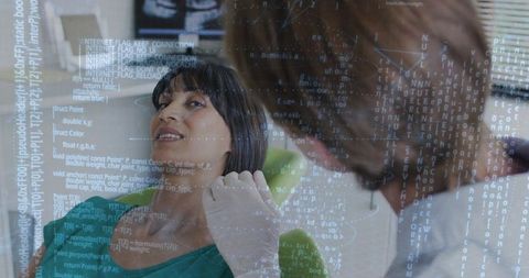 Patient reclining while clinician wearing gloves examining mouth with digital overlay