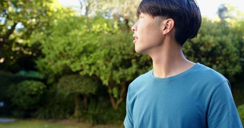 Serene Young Man Enjoying Nature in Sunlit Garden