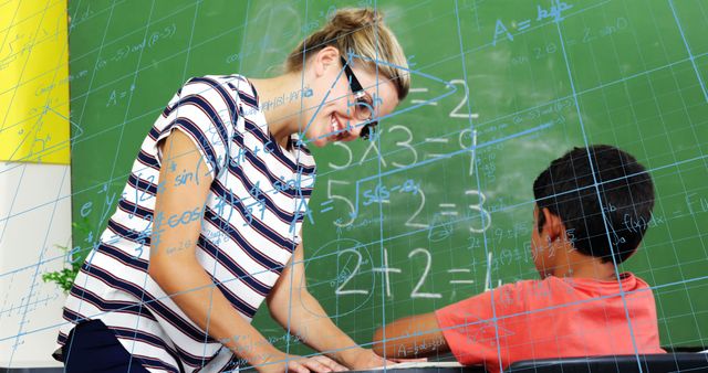 Image of mathematical equations over caucasian female teacher teaching a boy at school. School and education concept
