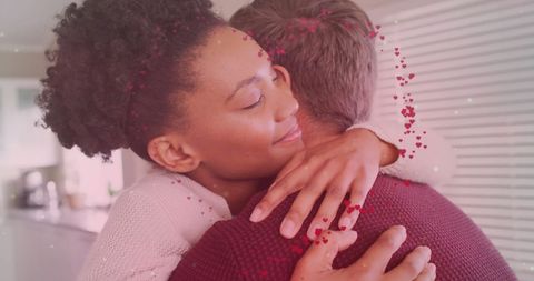 Diverse Couple Embracing in Kitchen with Love Symbolism