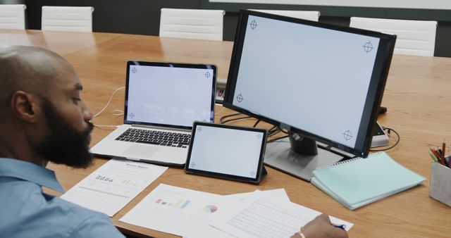 Businessman Analyzing Financial Reports and Data on Multiple Devices in Office - Download Free Stock Images Pikwizard.com